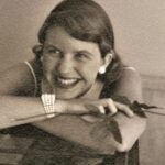 Sylvia Plath smiling with a rose in her right hand